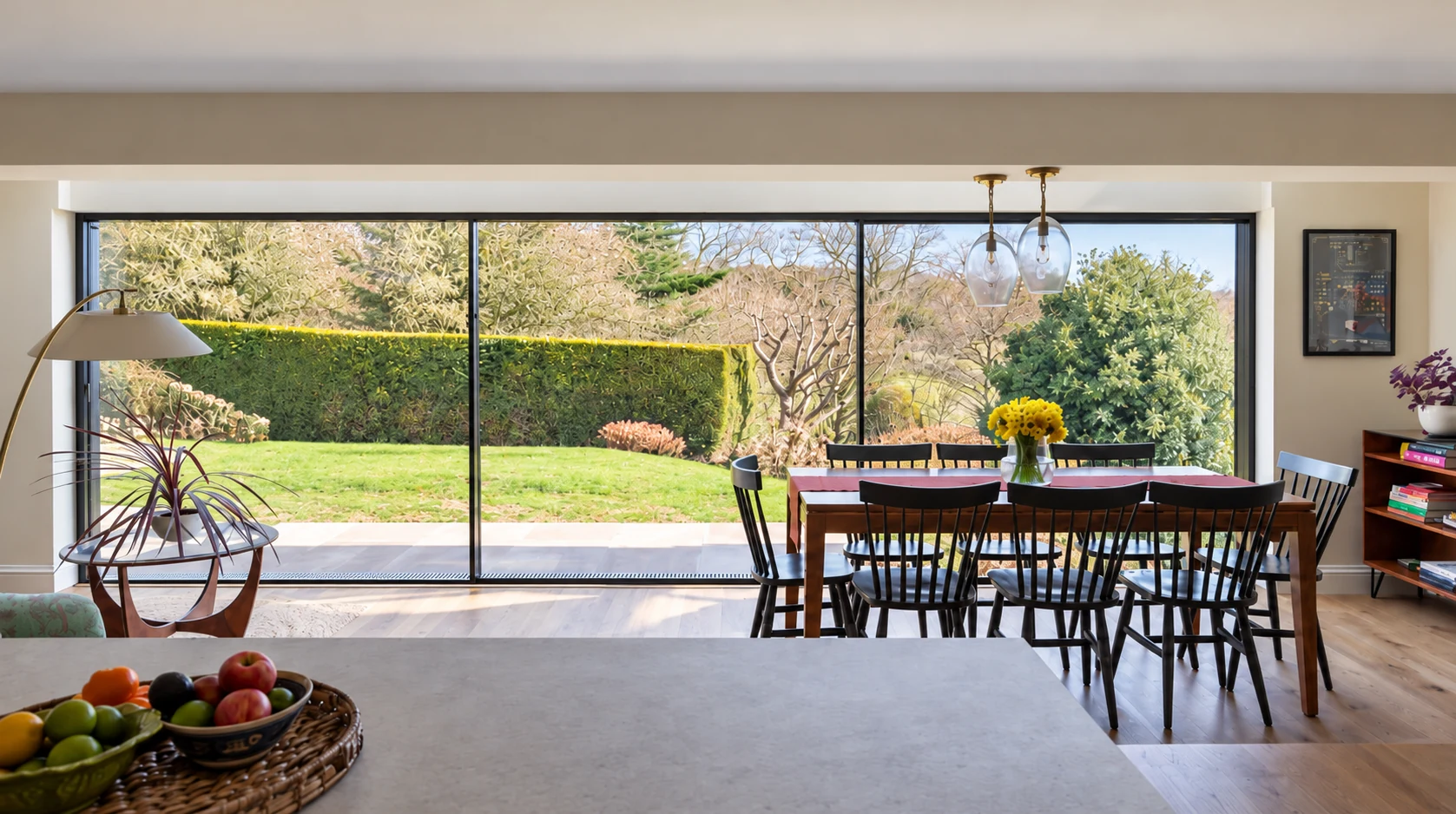 Contemporary dining room with expansive sliding glazing overlooking a landscaped garden
